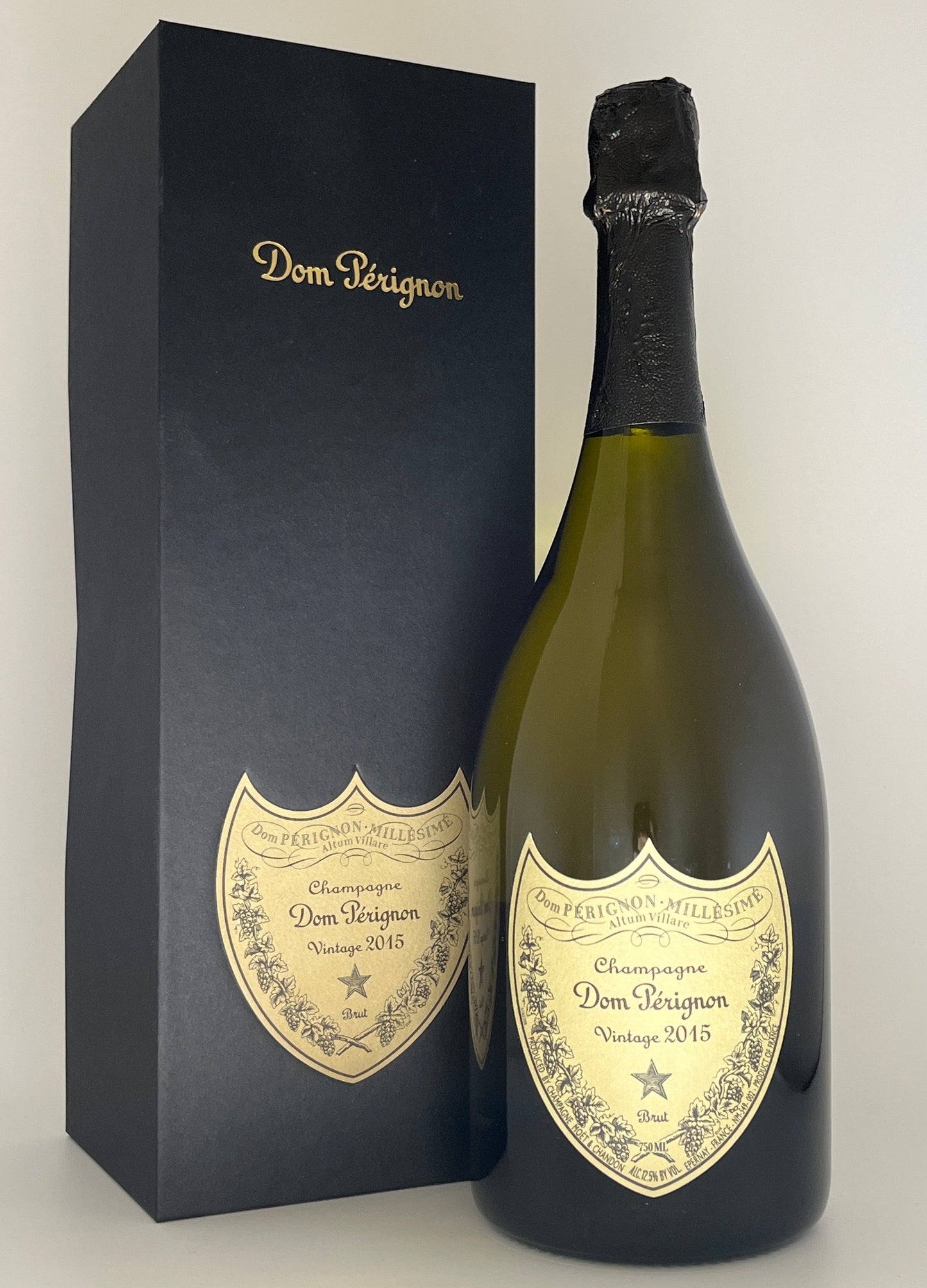 Bottle of Dom Perignon 2015 champagne with its packaging on a white background